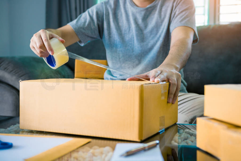 Asian entrepreneur teenagers are using the tape to seal the box