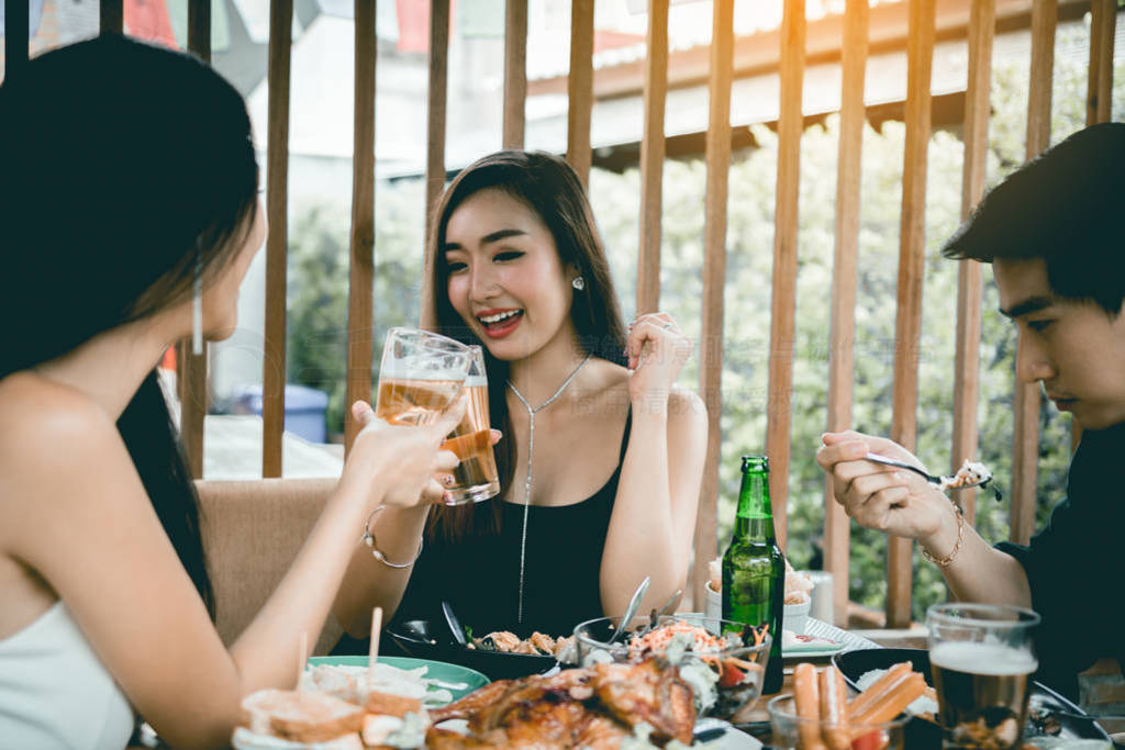 Group of asian people cheering beer at restaurant happy hour in