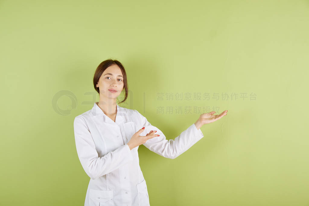 White-skinned female doctor doctor in a white coat points his ha