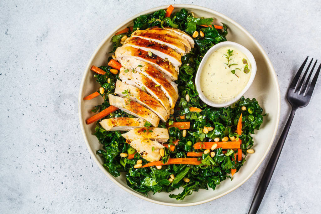 Grilled chicken breast salad with kale, pine nuts