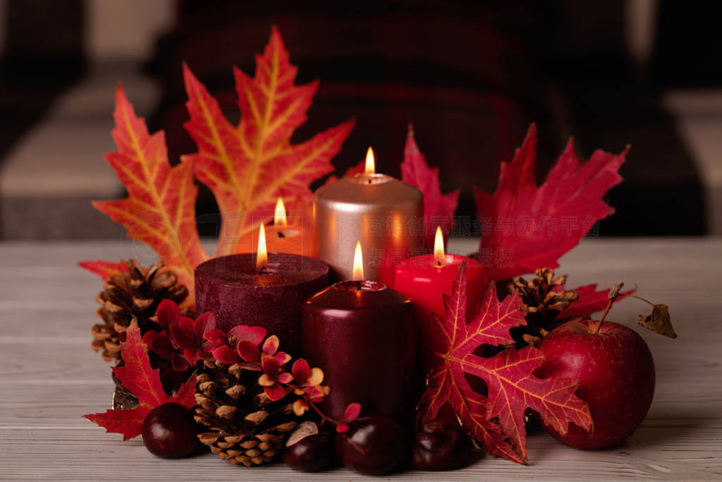 Autumn still life - candles, leaves and cones on the background