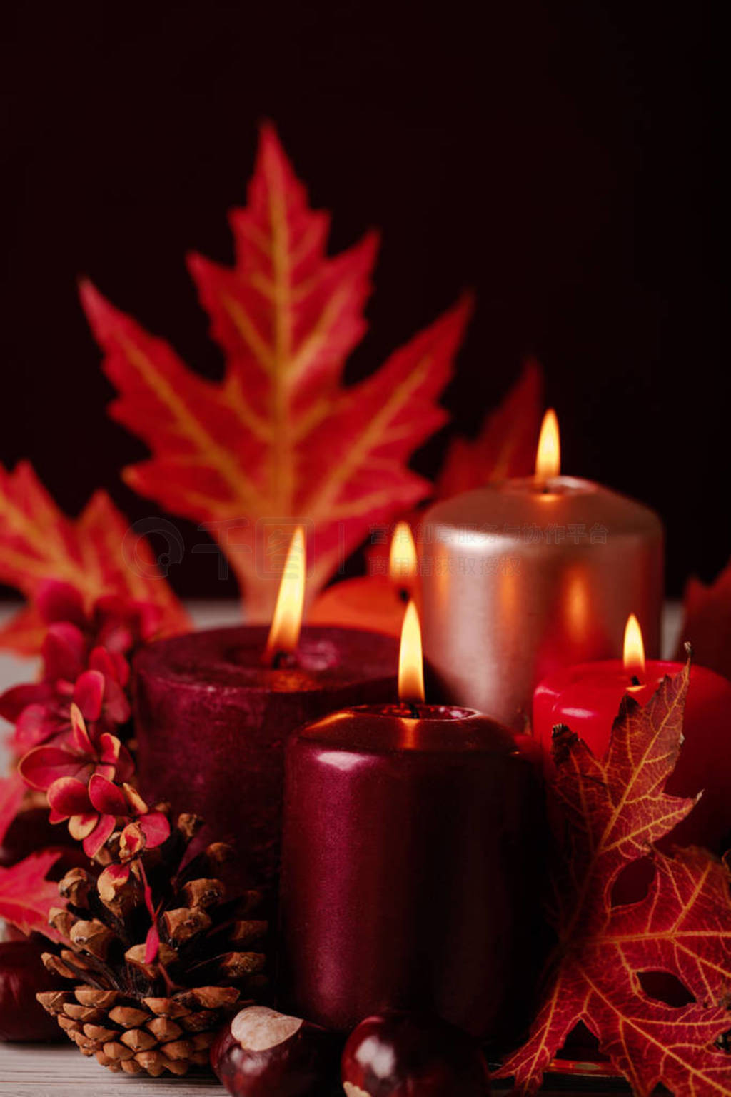 Autumn still life - candles, leaves and cones on the background