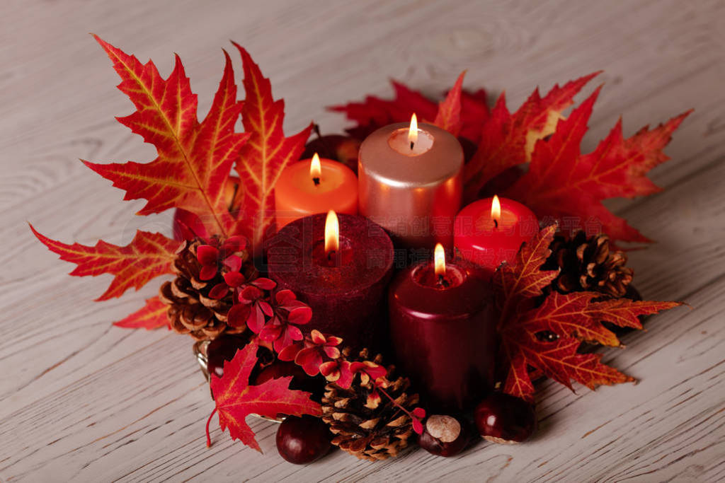 Autumn still life - candles, leaves and cones on the background