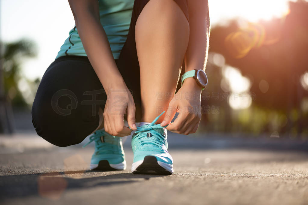Running shoes - closeup of woman tying shoe laces. Female sport
