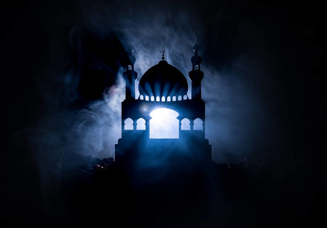 清真寺建筑剪影在柔和的雾背景。斋月的背景。清真寺日落。祈祷的人。选择性聚焦