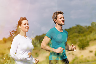 年轻的健身夫<i>妇</i>在户外运动 夏天在蓝天下的绿色草地上跑步