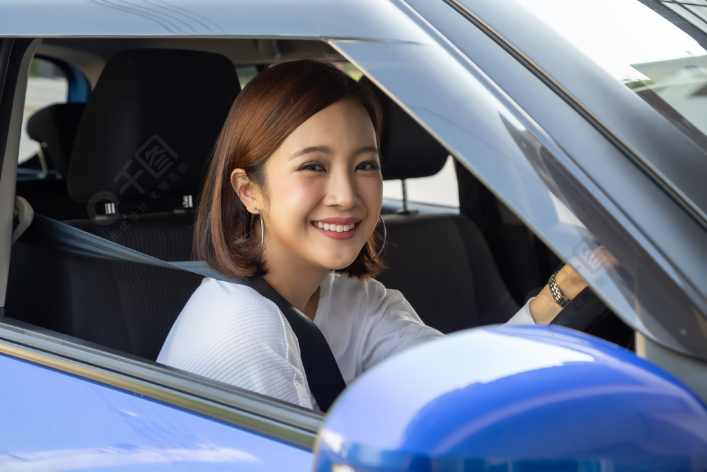 亞洲女性駕駛汽車在旅行途中用愉快的積極表情開心地微笑人們享受歡笑