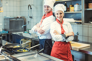 超级<i>骄</i>傲和酷的厨师在厨房里为镜头 男人和女人摆姿势