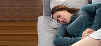 亚洲女性睡觉时肚<i>子</i><i>疼</i>得厉害沙发上有胃病的女孩