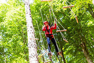 孩子在森林中的高绳索课程中<i>到</i>达平台攀登