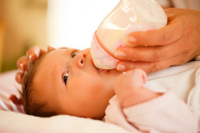 母亲 - 只能看到手 - 正在用奶瓶喂她的婴儿