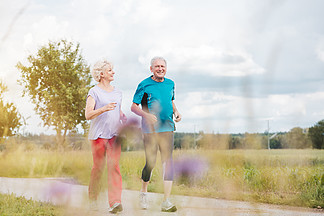 健康而活跃的老年夫<i>妇</i>在户外跑步作为夏季在小路上的锻炼