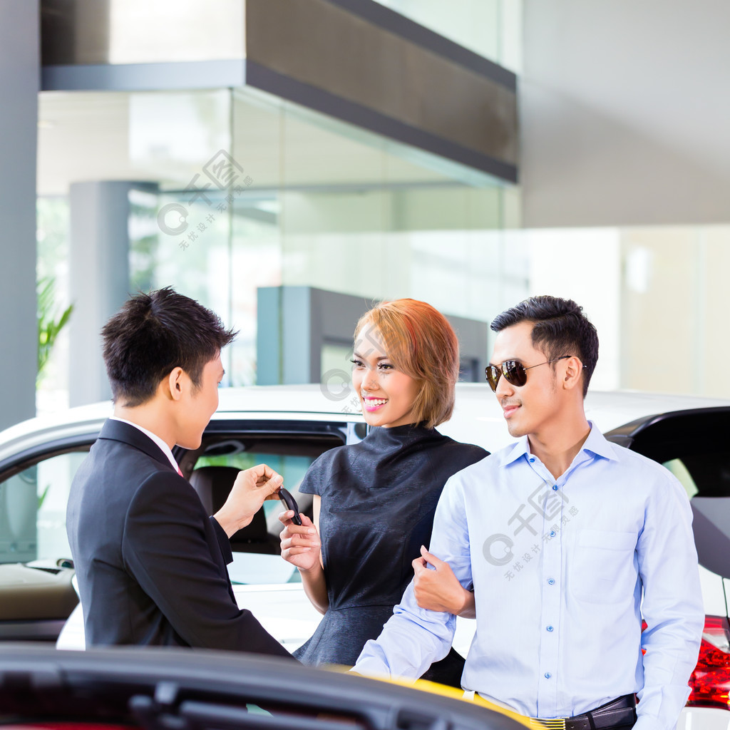 亞洲夫婦在汽車經銷店買車諮詢推銷員