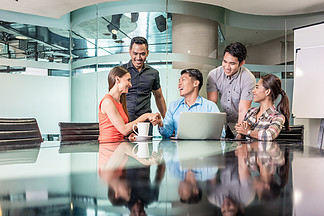 由五名敬业员工组成的多<i>民</i>族团队坐在笔记本电脑前 同时在现代办公室的创新业务项目中共同工作