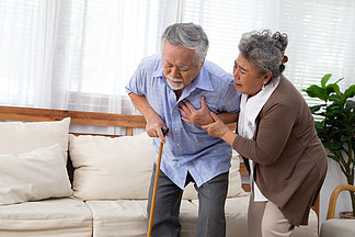 亚洲老人在客厅心脏疼痛 由妻子照顾 健康问题和身体<i>不</i><i>适</i>