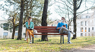 女人和男人戴着面罩 坐在公园的长椅上 与社会疏远地调<i>情</i>