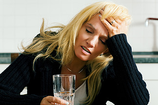 非常沮丧 <i>悲</i><i>伤</i>或脾气暴躁的女人用一杯水头痛（大概是在水中有止痛药）