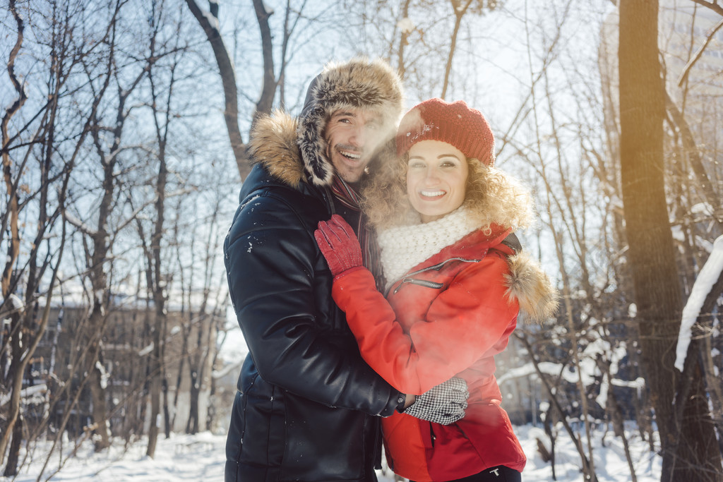 女人和男人在冬天在雪中寒冷晴朗的日子里互相拥抱