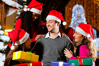 在人造<i>雪</i>覆盖的冷杉树和灯光下的购物中心里 圣诞老人在男性和女性变种中送圣诞礼物