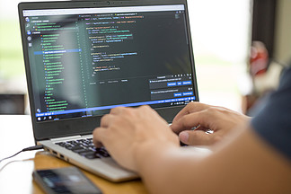在家工作并用笔记本电脑键入源代码的自由程<i>序</i>员或开发人员