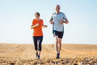 老年妇女和男子在田野上<i>跑</i>步或<i>慢</i><i>跑</i>以保持健康