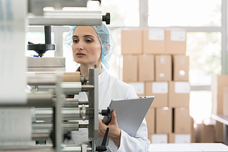 在化妆品厂内部进行质量控制期间检查设备和生产时 女性制造主管看起来很<i>担</i><i>心</i>