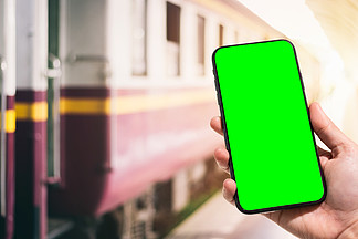 女性使用的特写手拿着智能手机模糊图像<i>触</i><i>摸</i>抽象模糊的离焦在火车站背景 绿色屏幕