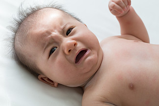 婴儿哭闹是绞痛症状 新生儿悲伤 婴儿尖叫 白<i>床</i>上饥饿的母乳喂养
