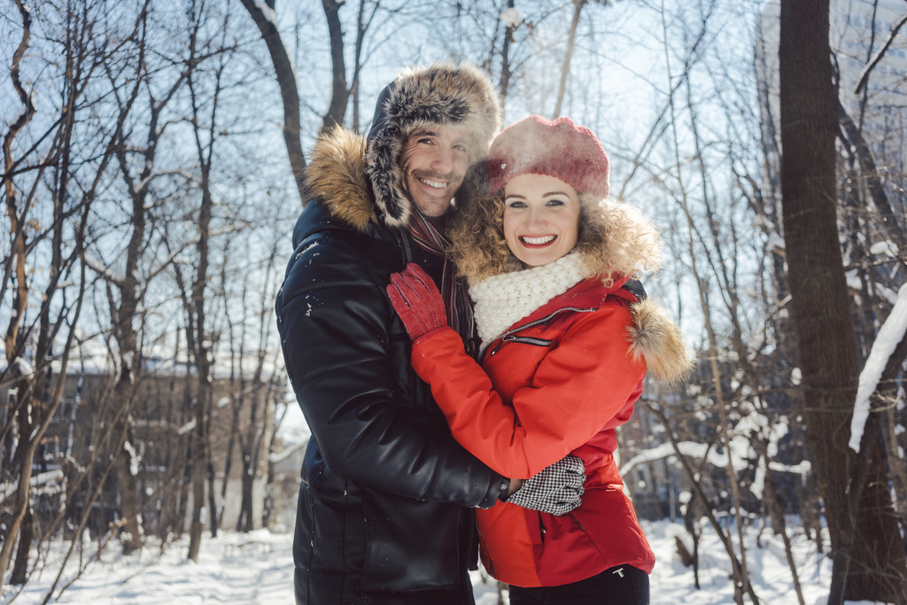 女人和男人在冬天在雪中寒冷晴朗的日子里互相拥抱