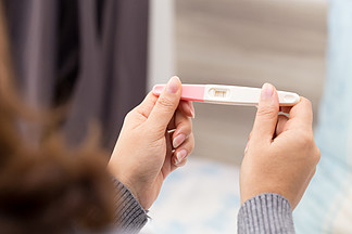 女人手拿排卵试纸 试图怀孕 收集尿液 放试纸 结果呈阳性