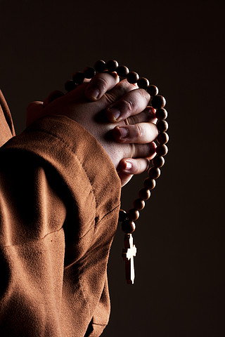 僧侣穿着长袍,双手合十祈祷
