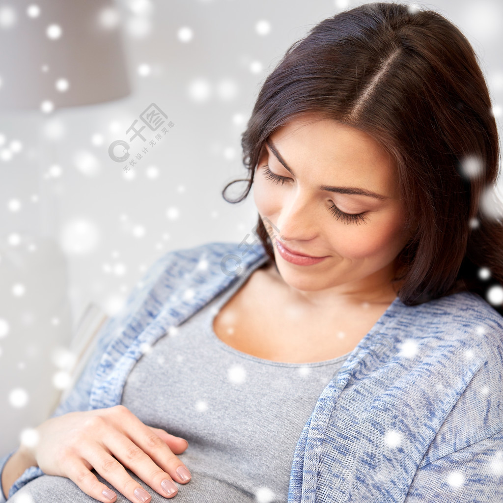 怀孕产假冬天人们和期望的概念快乐的孕妇与大肚子在家躺在沙发上在雪