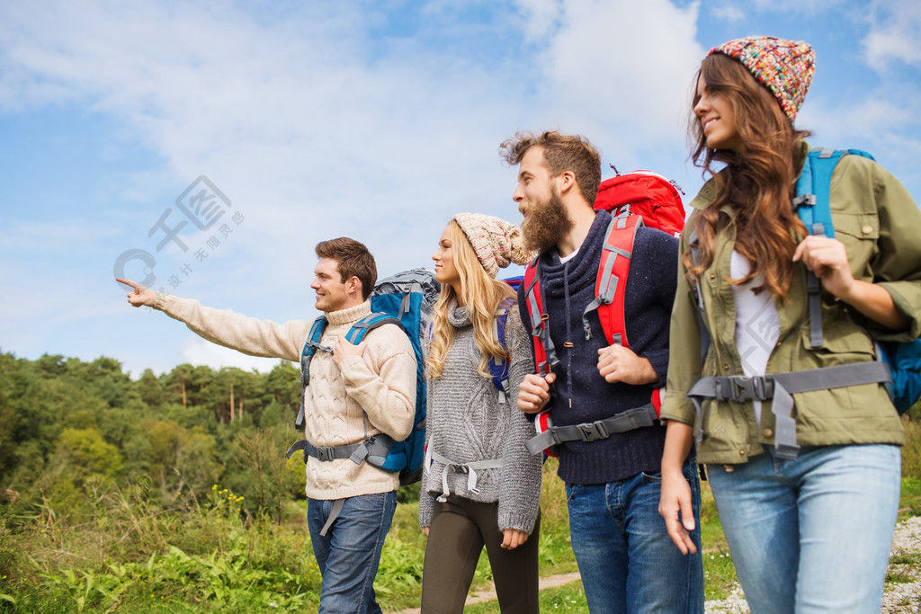 冒险,旅行,旅游,徒步旅行和人们观念-群微笑的朋友,背着背包走