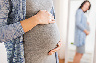 怀孕，孕产，人们和期望概念-接近有看大的腹部的愉快的孕妇在家在家<i>反</i><i>映</i>