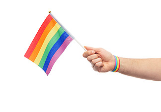 <i>lgbt</i>，同性关系和同性恋概念-接近佩带同性恋自豪感了悟腕带的男性手拿着彩虹旗子同性恋骄傲彩虹旗和腕带的女性手手与同性恋骄傲彩虹旗和腕带