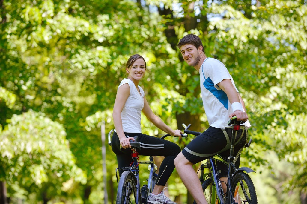 幸福的夫妇骑着自行车在户外健康的生活方式乐趣爱浪漫的概念