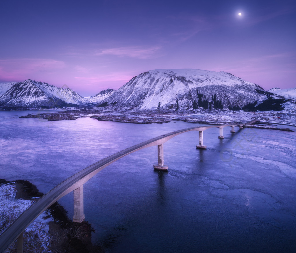 反射鸟瞰图在水中与桥梁,多雪的岩石,黄昏的蓝色海的夜风景冬天在罗弗