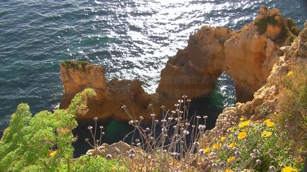 Blick auf Felsengebilde Steine im blauen Meer von einem mit bunten Blumen bewachsenen Felsen?ڡ