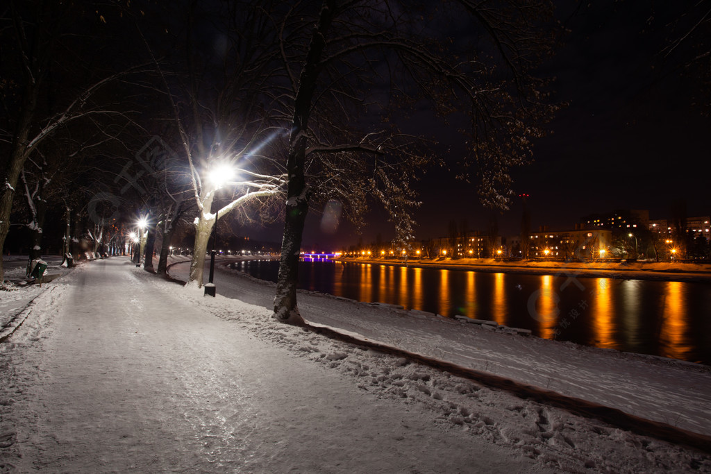 積雪的堤防在晚上城市美麗的冬天風景大雪覆蓋的路堤的夜景