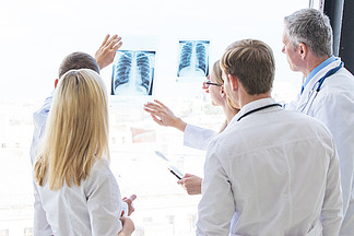 小组医生讨论X-射线一<i>群</i>医生在诊所或医院<i>看</i>和讨论X射线