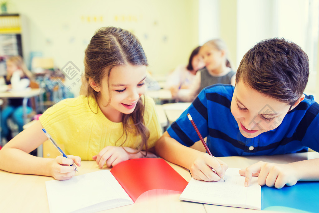 教育,小学,学习和人们观念-组的学校孩子们用笔和笔记本在教室里写