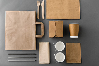 包装，回收和饮食概念-外卖食品的一次性纸容器与杯子，袋子，餐巾和利器在桌上一次性纸外卖食品包装材<i>料</i>