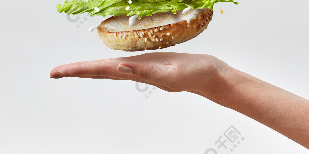 女手在白色背景上飞行从美味肉片和新鲜的天然食材自制汉堡地方上的一个女人的手文本 Deliciouse自制汉堡包在白色背景上飞行的新鲜食材复制空间