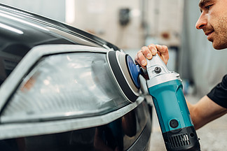 自动提供洗车服务中的汽车大灯细节工人用抛光机<i>清</i>洗玻璃