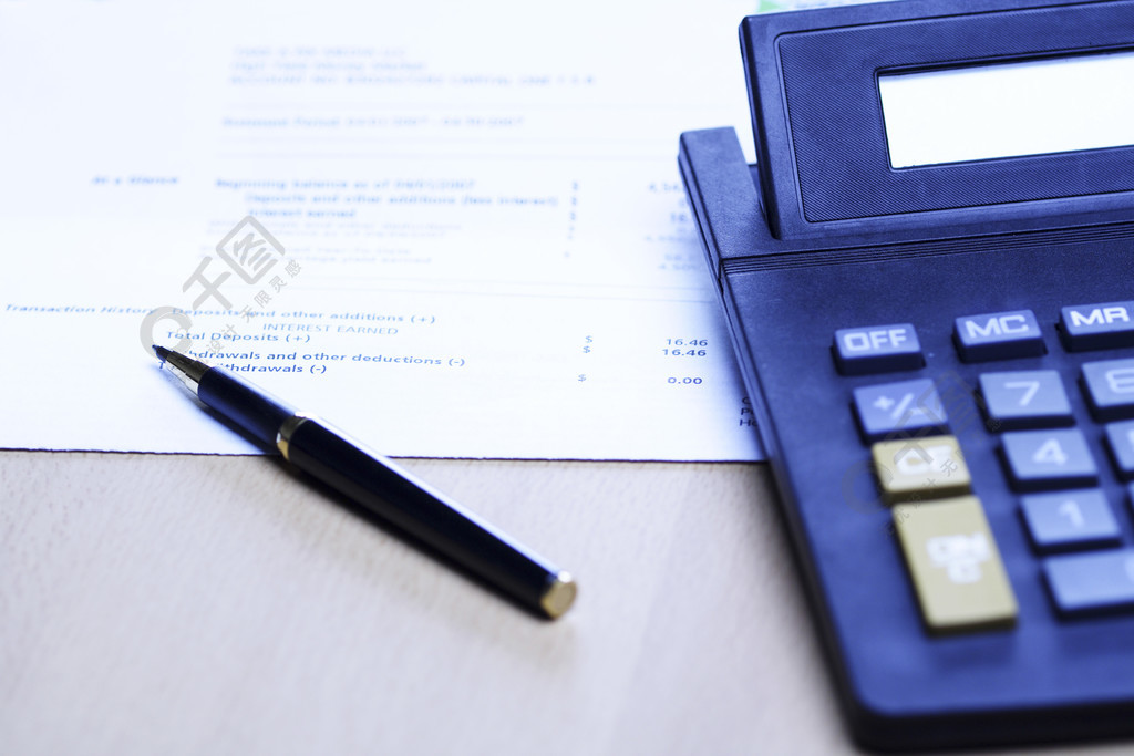 一支笔和一个计算器的图象在一个财务报表顶部，可以为企业财务和会计概念使用（射击在蓝色口气）