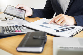 在书桌办公室企业财务分析图或图表会计的商人工作计算的bugget金钱税贷款审查员做报告
