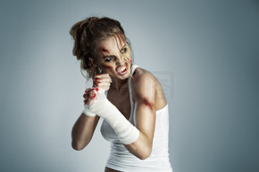 站立在与血液的战斗位置的妇女照片在面孔和拳头