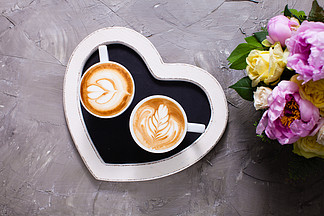 在两杯热奶咖啡的拿铁艺术在心脏形状盘子上早上快<i>乐</i><i>情</i><i>人</i>节<i>情</i>侣爱的<i>情</i>侣卡布奇诺咖啡