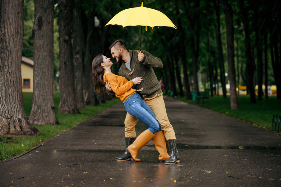 幸福的愛情侶在夏 i>天 /i>下雨 i>天 /i>在公園裡跳舞男人和女人在