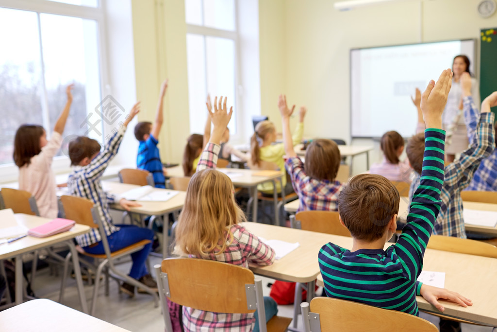 教育,小学,学习和人概念-举在教训的小组学生手在教室一群学校的孩子